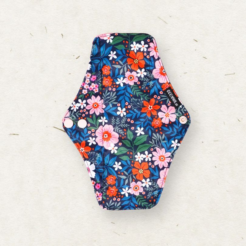 Eco Mini - Hexagonal floral-patterned cloth sanitary pad on a light gray background