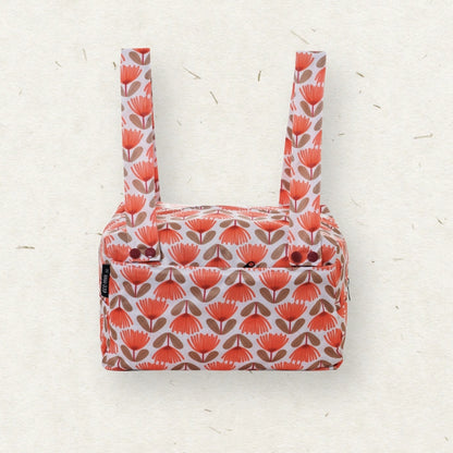 Eco Mini Cloth Diaper POD - with a retro mid-century floral pattern in coral orange, brown, and white, featuring two shoulder straps and a zippered top closure, set against a textured off-white background.