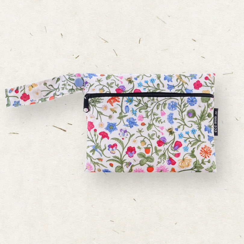 A small wet bag with a colorful wildflower print on a white background, featuring a matching wrist strap and a black zipper.